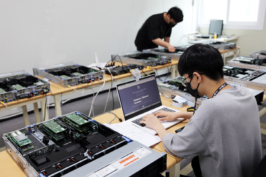 코오롱베니트가 광명 물류센터에 '파트너 검수 지원센터'를 개소했다. 센터에 방문한 파트너사 임직원이 장비를 테스트하고 있다.   코오롱베니트 제공